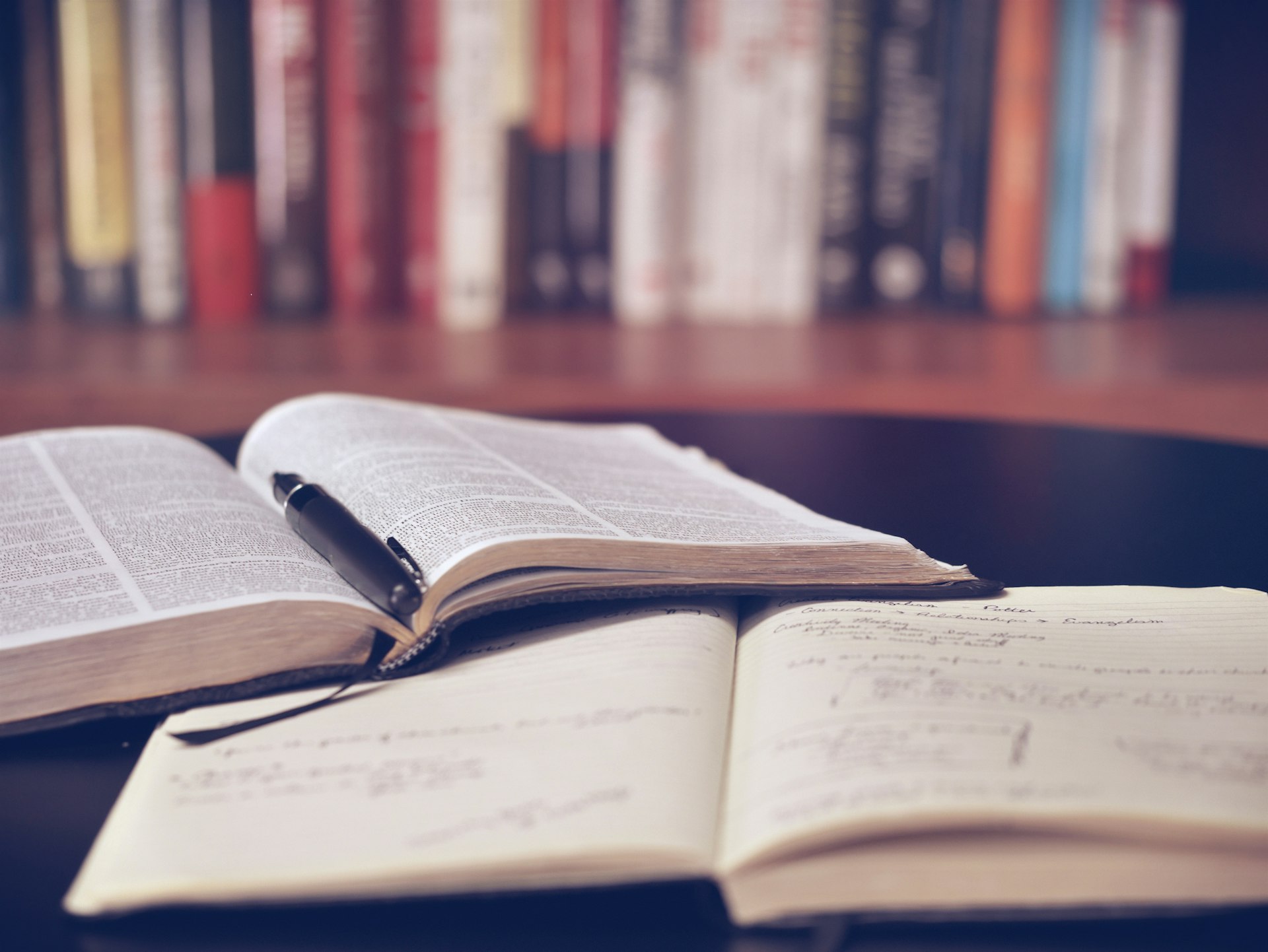 Reading glasses resting on an open book in warm light